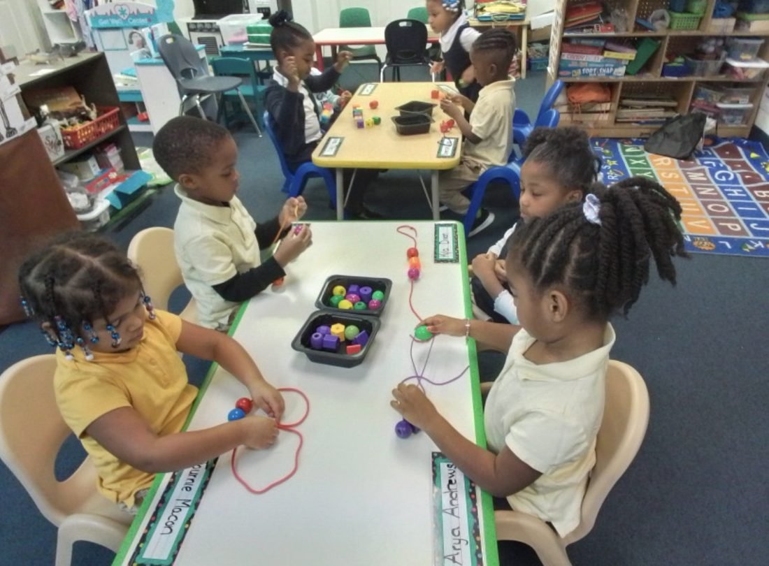 Early Explorers toddlers practicing fine-motor bead lacing