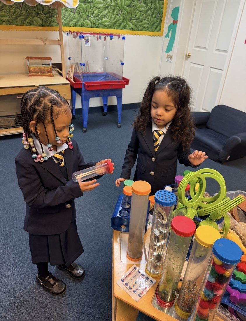 Preschool Academy scholars in uniform exploring sensory science tubes